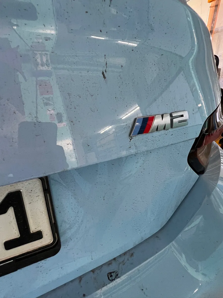 Verschmutztes Heck eines BMW M2 mit Schmutz- und Wasserspritzern