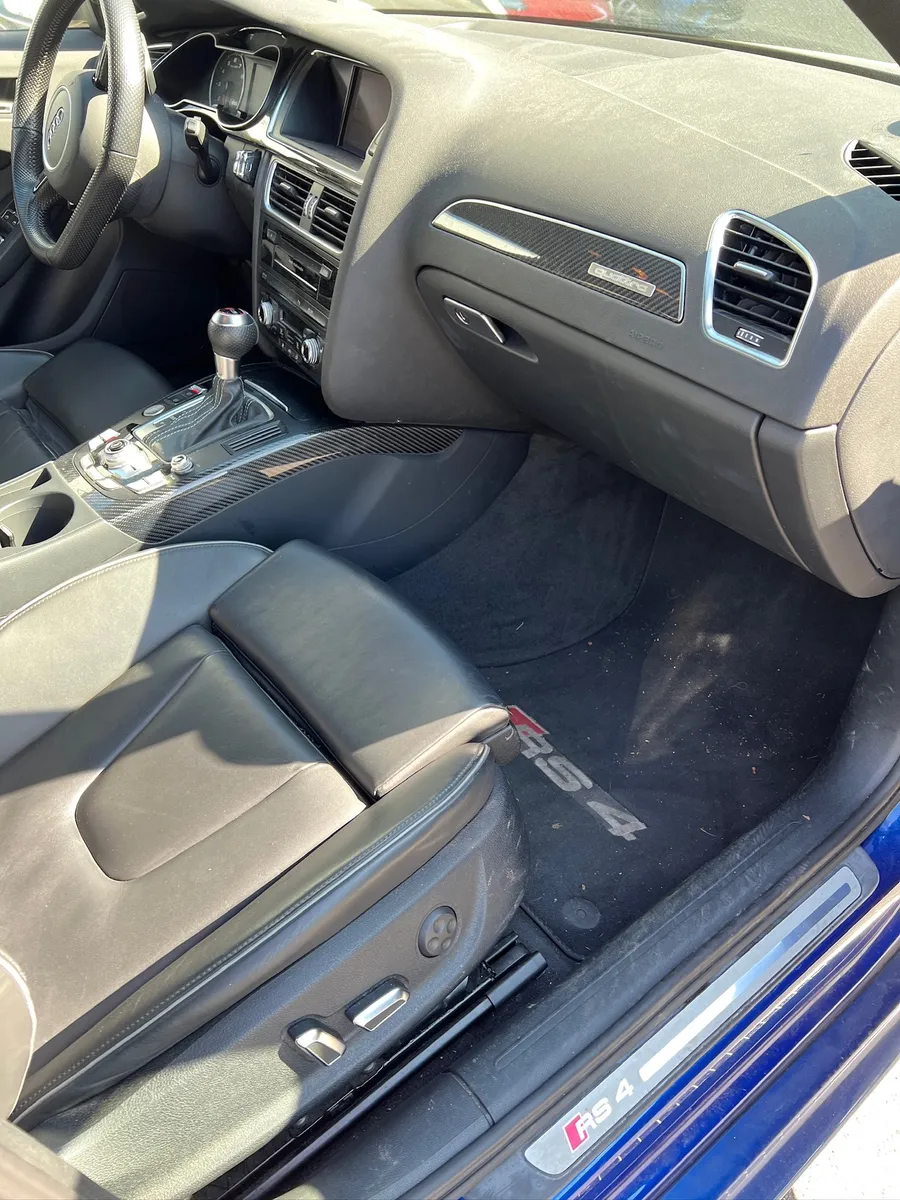 Beifahrerbereich eines Audi RS4 vor der Reinigung mit Staub auf Armaturen und Matte